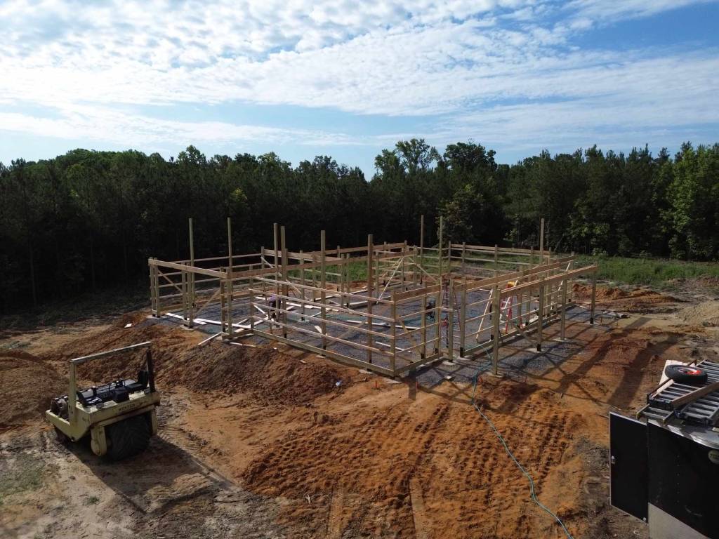 "under construction at a residential building site with large wooded area in the background, working construction site for...