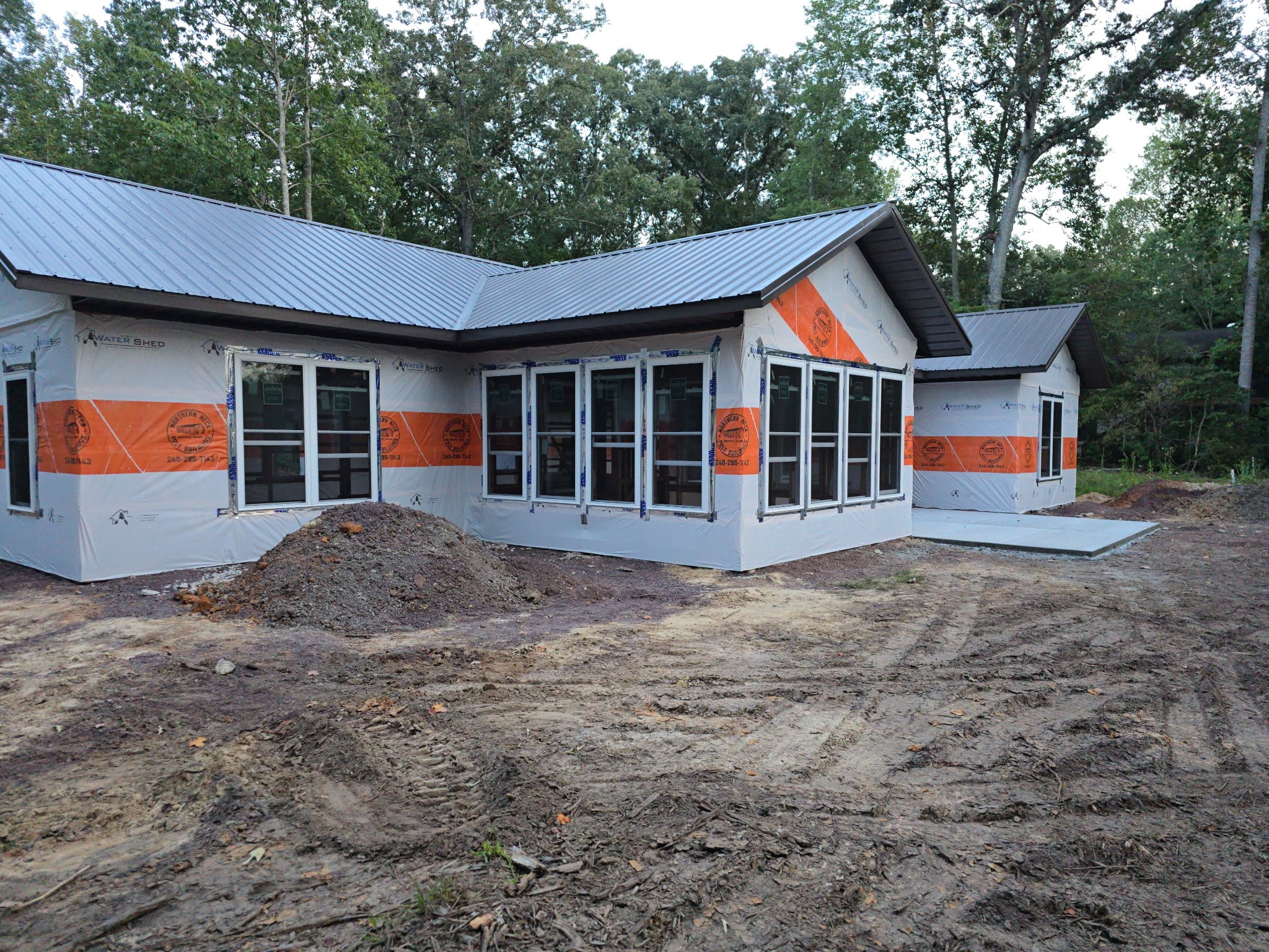 A house under construction featuring exposed building materials, visible through its incomplete exterior, with rubble scat...